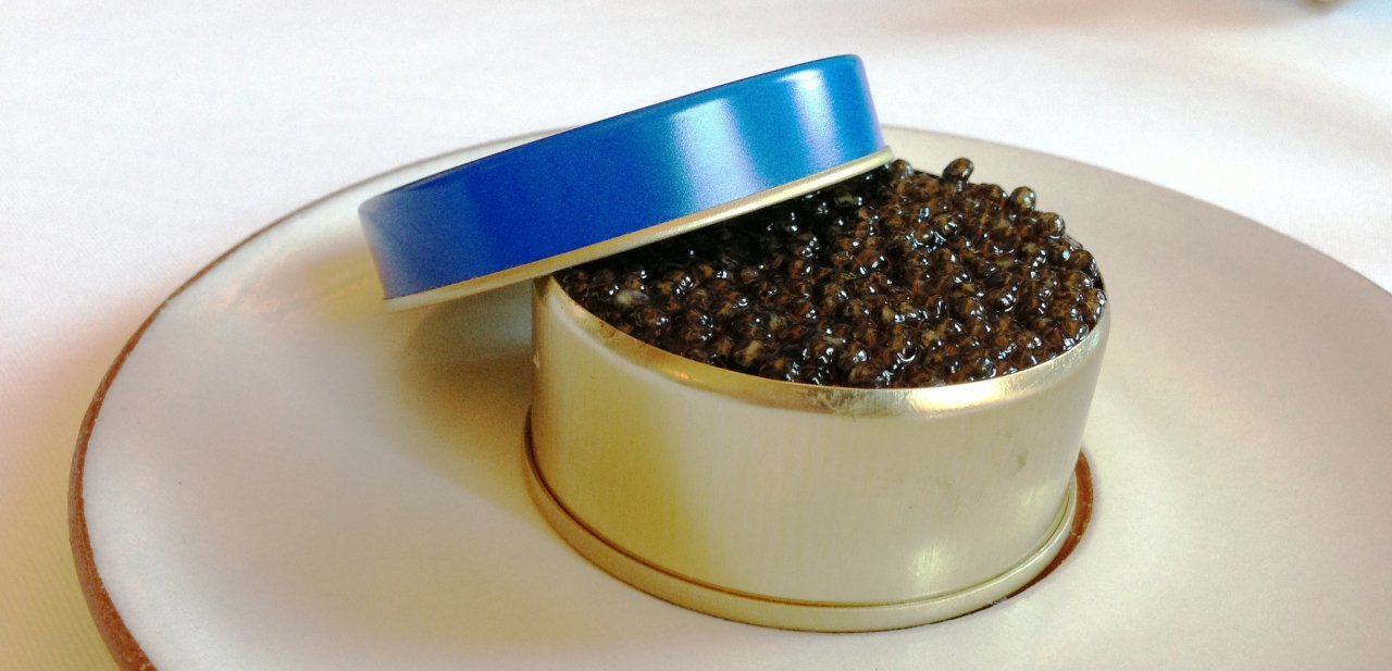 Una lata de caviar abierta sobre un plato